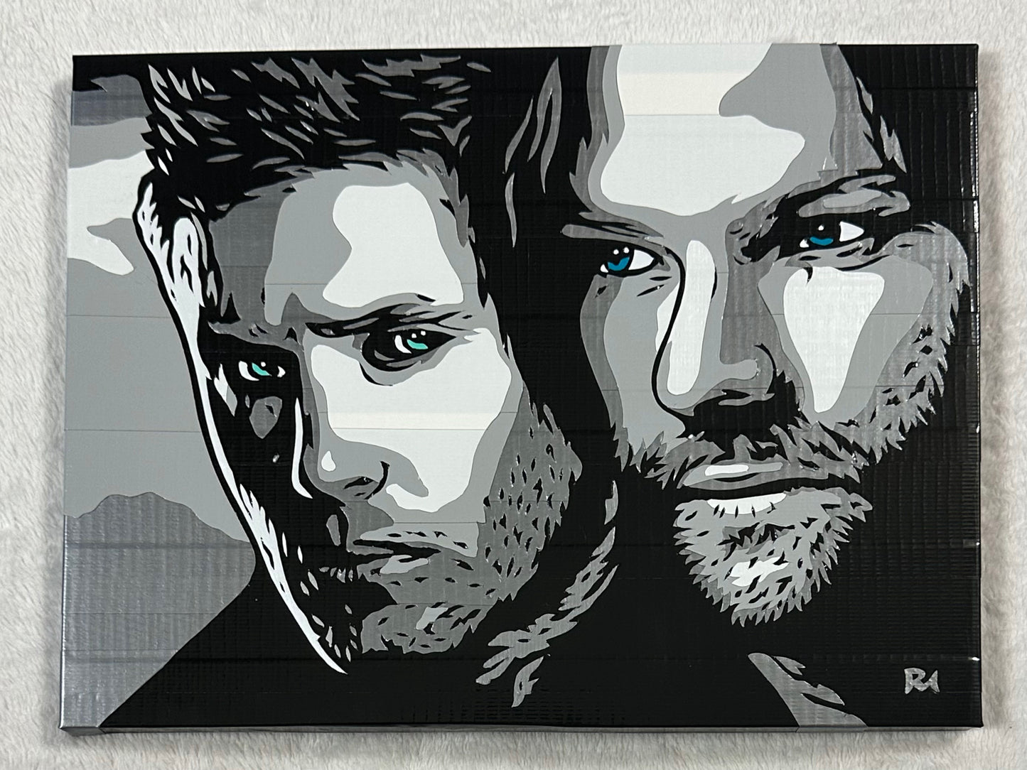 A black and white image of Sam and Dean Winchester, created with different shades of duct tape, on a white background.