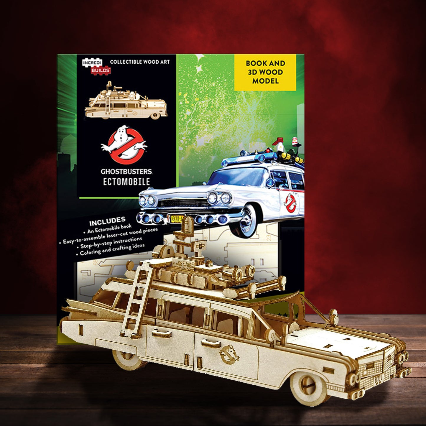 An image of a green box cover on a wooden table against a dark red background, with a drawing of the Ectomobile from the movie Ghostbusters on the right side. A black rectangle at the top shows a picture of the assembled wood model, with the Ghostbusters logo beneath it. At the bottom of the box cover is an image of the wooden model pieces, ready to be assembled.