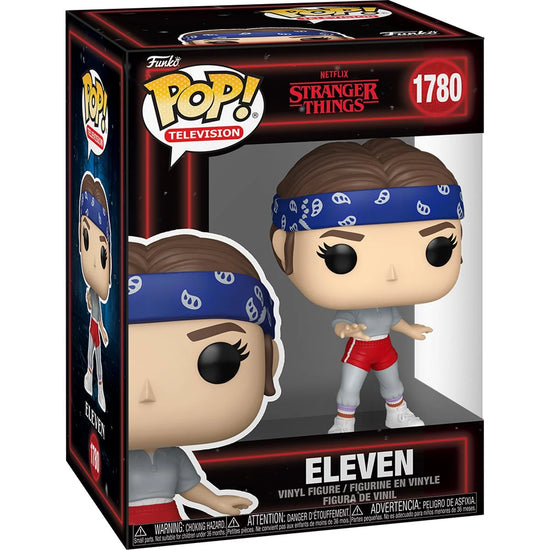 A cardboard box with a transparent front, containing a bobblehead figure depicting Eleven from the TV series Stranger Things. She is wearing gym clothes and a blue headband.