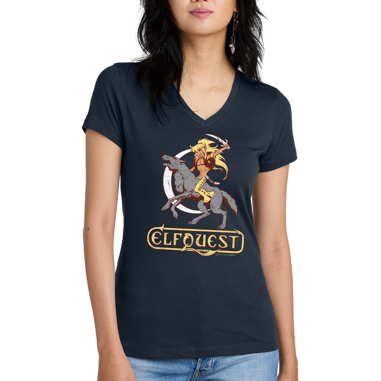 A female model wearing a dark blue v-neck shirt. On the front is a drawing of the character Cutter from the ElfQuest comic series, riding on a giant grey wold and brandishing a curved dagger. In the background is a narrow, white sliver of the moon.