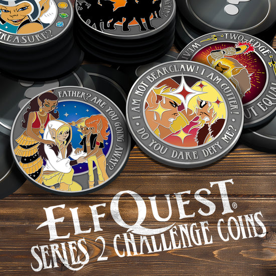 A pile of grey challenge coins on a wooden table. The front coin shows two ElfQuest characters glaring at each other. The left coin shows Cutter and his family. The back coin shows Two-Edge forging a knife. A back left coin shows Skywise and a coin beside that shows a group of wolfriders.