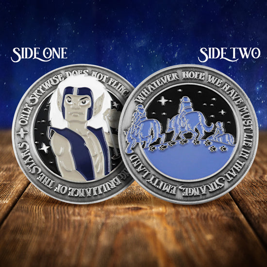 Front and back images of a brass challenge coin, on a wood table. The front of the coin depicts the ElfQuest character Skywise, with raised text saying “only “Skywise does not flinch from the piercing brilliance of the stars” around the edge. The back depicts a elves riding on wolves in blue on black, with raised text saying “whatever hope we have must lie in that strange, empty land.” Behind the coin is a starry nighttime sky.