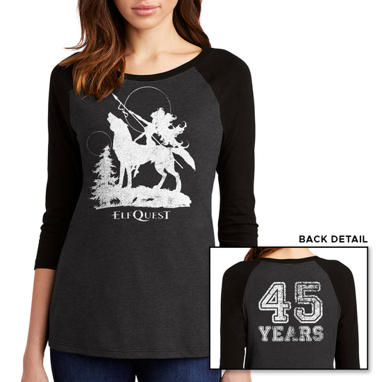 Two images of a female model wearing grey long sleeve T-shirt with black sleeves. The larger image has a white image of an elf riding on the back of a large howling wolf, next to a small tree. The elf is holding a spear, and pointing it toward the sky. Under the wolf is text saying "ELFQUEST." The smaller image shows the back of the shirt, with "45 Years" printed in large white text.