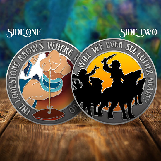 Load image into Gallery viewer, Two challenge coins side by side on a wooden table, with a swirling green and blue pattern in the background. The left coin shows a hand holding a rock on a string. Around the edge is text saying &amp;quot;the lode stone knows where we want to go.&amp;quot; The right coin has silhouettes of elves riding on wolves, against a sunset colored background. Around the edge is text saying &amp;quot;will we ever see cutter again?&amp;quot;
