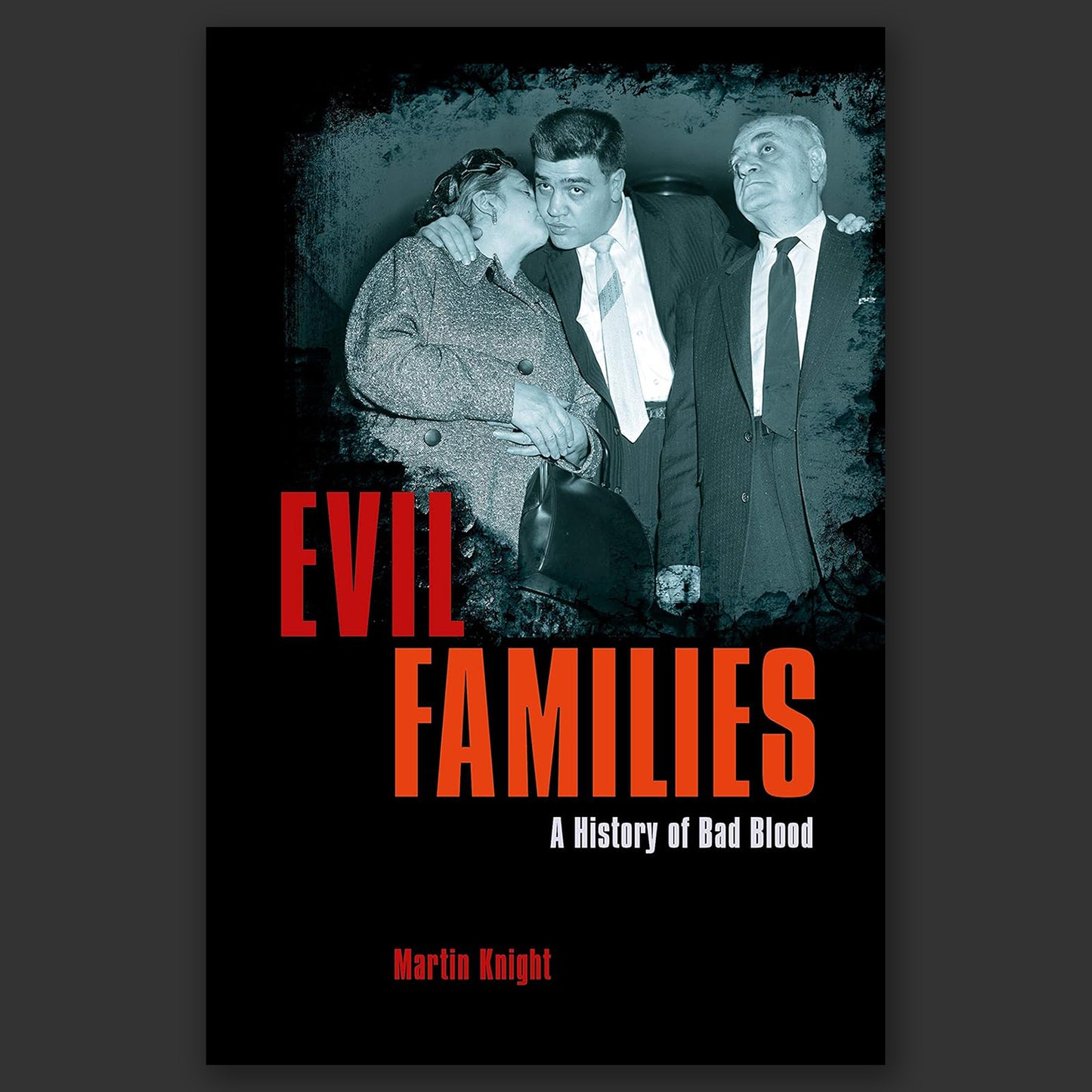 A black paperback book on a grey background. On the cover is a black and white photograph partially showing three people from the 1930s. Red and white text says "Evil Families. A history of bad blood."