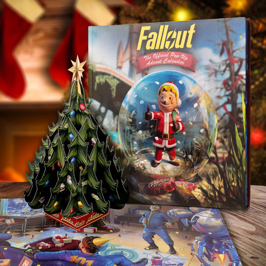 Pop-up Advent Calendar for 'Fallout' with a character in a snow globe against a dystopian backdrop. Next to the calendar are some of the items included. Behind the calendar is a Christmas tree and red stockings.