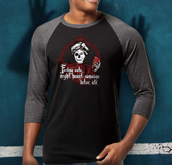Load image into Gallery viewer, A male model wearing a grey and black baseball shirt. He is standing against a blue background, with a shadowy figure in the center. On his shirt is a skeletal figure holding a red cell phone, surrounded by a red filigreed border. Under the figure in white text is &amp;quot;feeling cute, might haunt someone later, IDK.&amp;quot;
