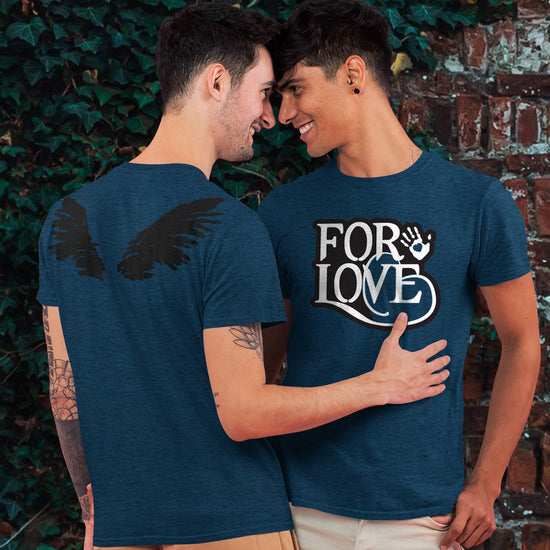 Two male models embracing, with their heads touching. Each is wearing a teal t-shirt. On the back of the shirt is a drawing of black angel wings. On the front is white text with a black border that says "For love." Next to the text is a white drawing of a hand, with a blue heart in the center of the palm. Behind the models is a brick wall covered with green ivy.