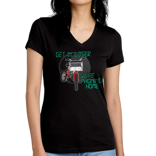 A model in a black tee shirt against a white background. On the front is a drawing of a red bike with a basket in the front. Above and below the bike is green text saying "Get in, loser, we're phoning home," stylized to look like text from old electronics.