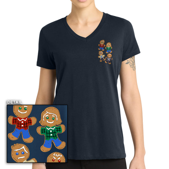 Person wearing a navy blue t-shirt with gingerbread people design on a white background