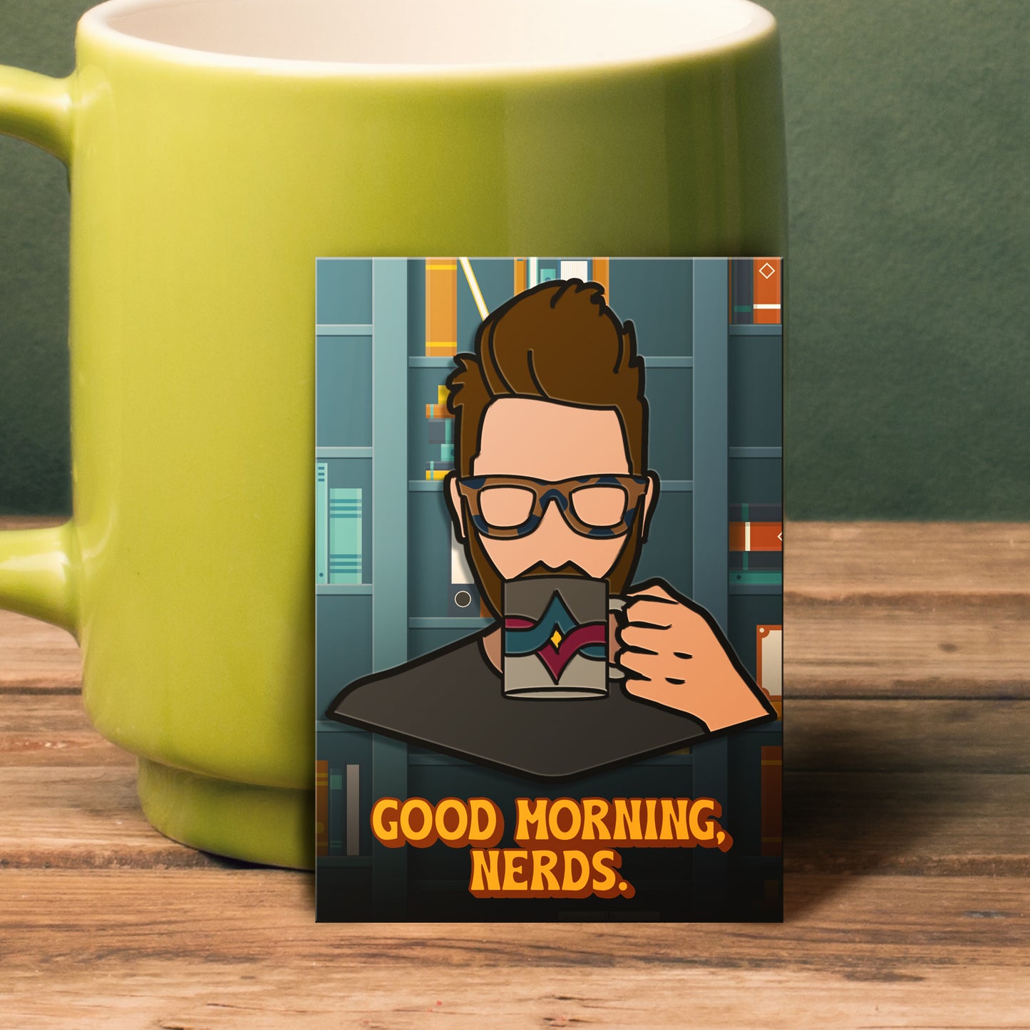 An enamel pin leaning against a green coffee mug. The pin has a stylized drawing of actor Wil Wheaton sipping from a coffee mug. The mug has a red and blue crossed line pattern against two shades of grey. At the bottom is yellow text saying "good morning, nerds."