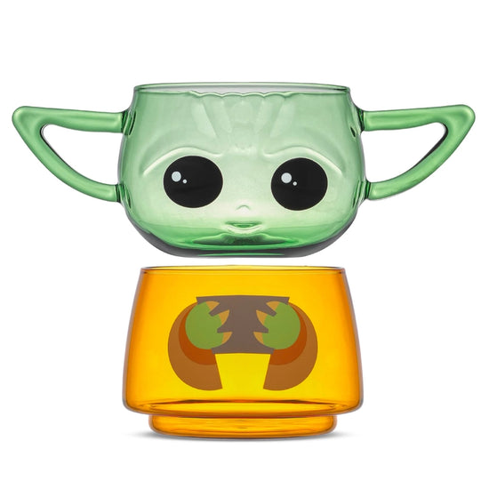 Two small drinking glasses stacked on each other against a white background. The two glasses combined depict the character Grogu from the Star Wars series The Mandalorian. The top glass has two handles shaped as his ears. The two glasses are slightly separated from each other.