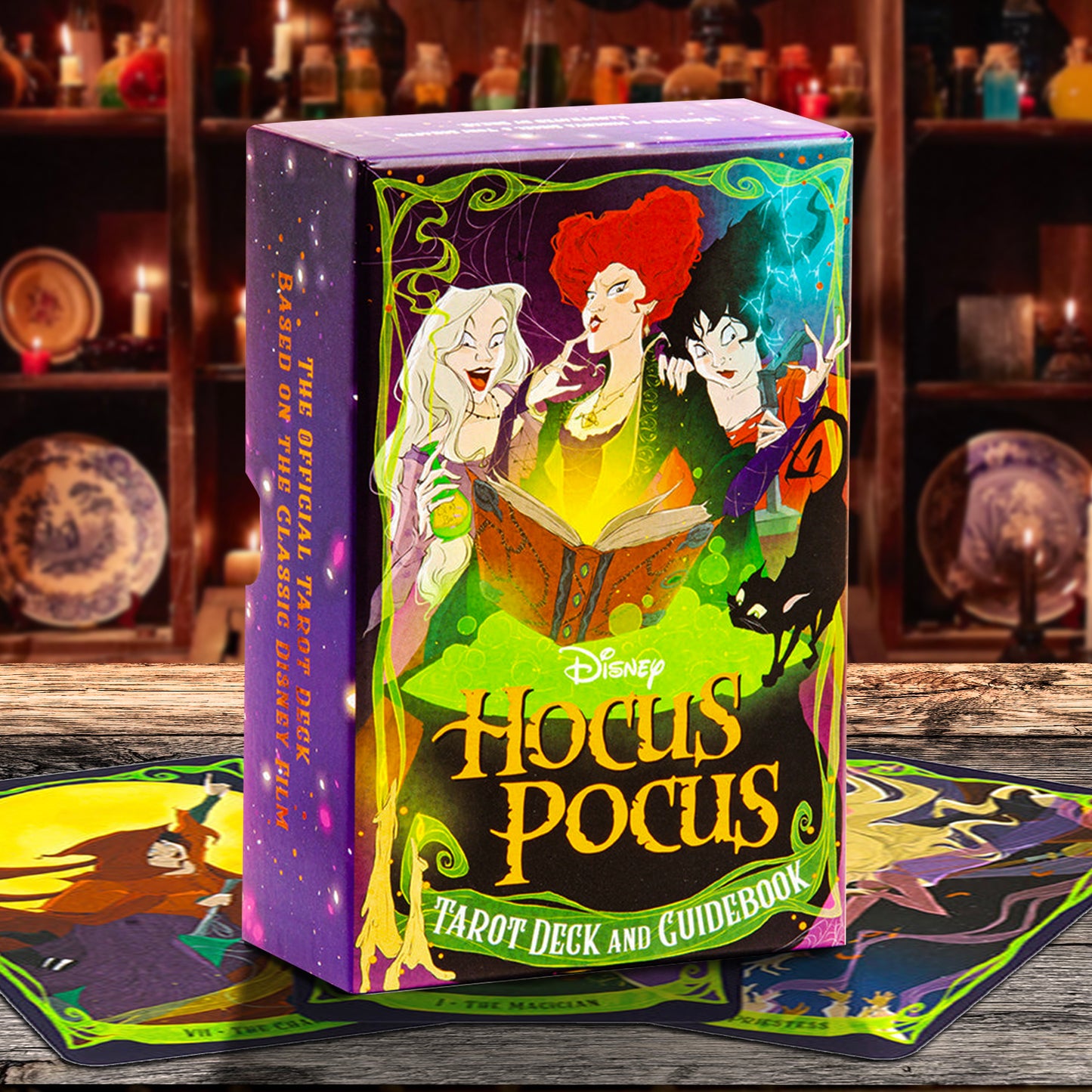 Disney Hocus Pocus Tarot Deck and Guidebook box standing upright on a wooden surface, with tarot cards spread around it and a dark, mystical shelf background.