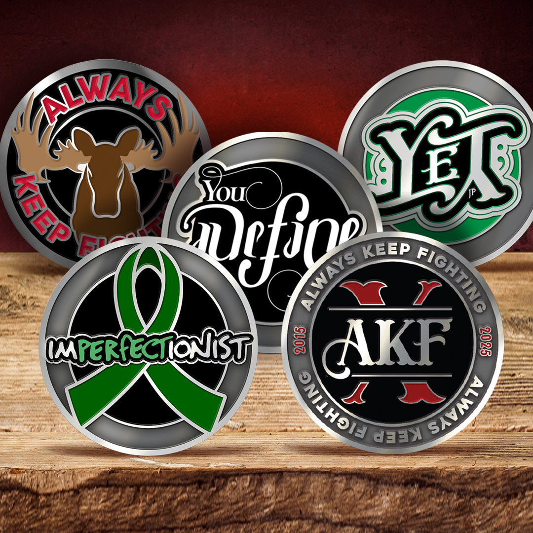 Five metal coins with engraved text and designs on a wooden surface.