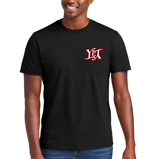 A male model wearing a black tee shirt. On the left side are the letters YET in white, outlined in red. The letters are designed to spell the word "yet" right side up and upside down. 