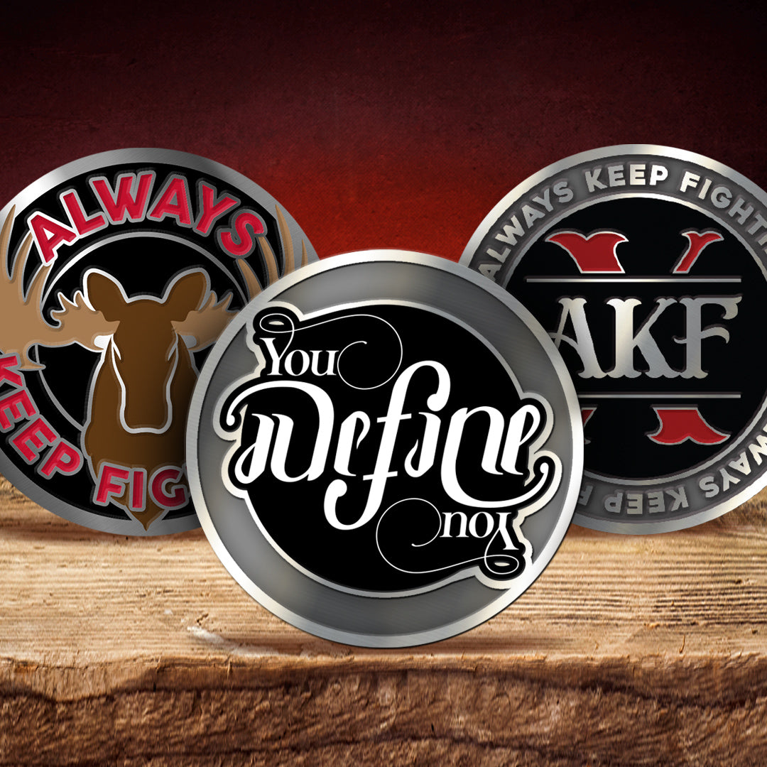 Three metal coins with engraved text and designs on a wooden surface.