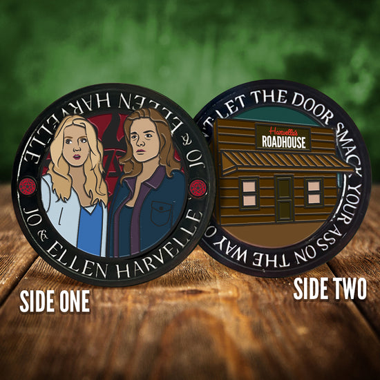 Front and back images of a challenge coin, side by side, on a wood table. The front depicts a drawing of Jo and Ellen Harvelle. Behind them is the edge of the anti-possession symbol. The back of the coin depicts a roadhouse bar, and a sign saying "Harvelle's Roadhouse" White text around the edge says "Don't let the door smack your ass on the way out."