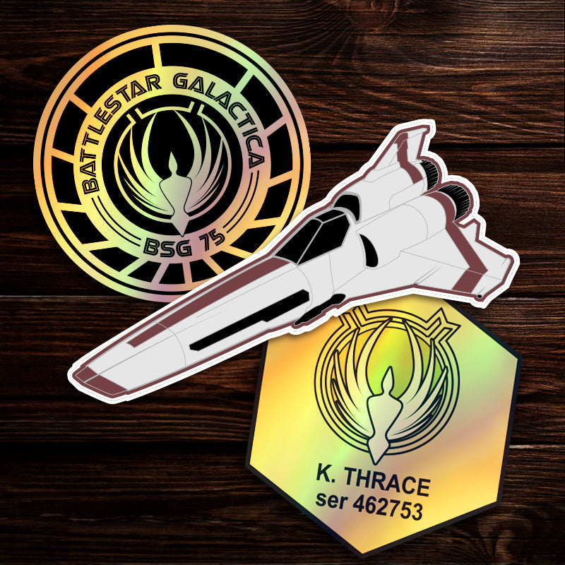 Three Battlestar Galactica themed stickers on a wooden table