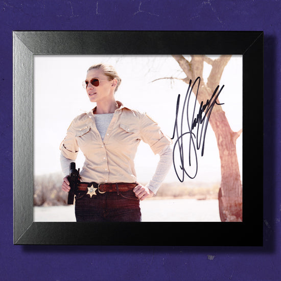 A framed image against a purple wall. The image shows actor Katee Sackhoff as the character Vic Moretti, from the TV series "Longmire." Across the front of the image is Katee's autograph.