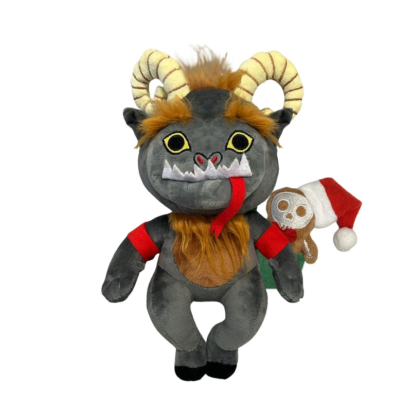A grey plushie depicting the mythological figure Krampus. At the top of his head are yellow horns and patches of brown hair. Across his face are white fangs, and a long red tongue. A small gingerbread figure wearing a santa hat is on the plushie's back.