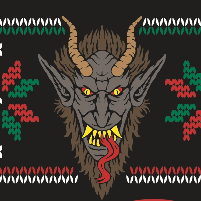Close up of a sock, which depicts the face of the mythological figure Krampus, with long horns on his head, sharp teeth, and a long red tongue