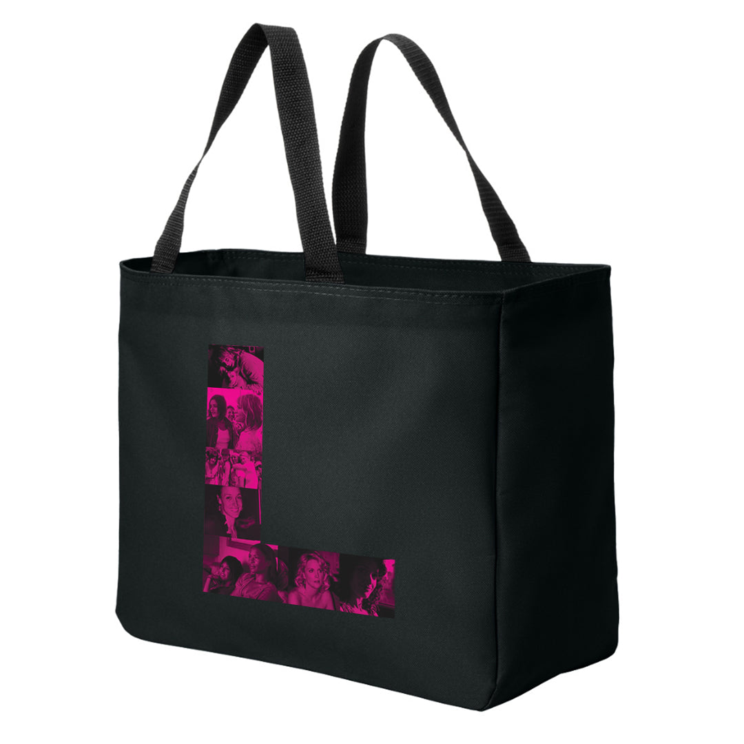 A  black tote bag with black handles against a white background. On the front of the bag is a pink letter L. Inside the L are pink and black images of characters from the TV series The L Word.