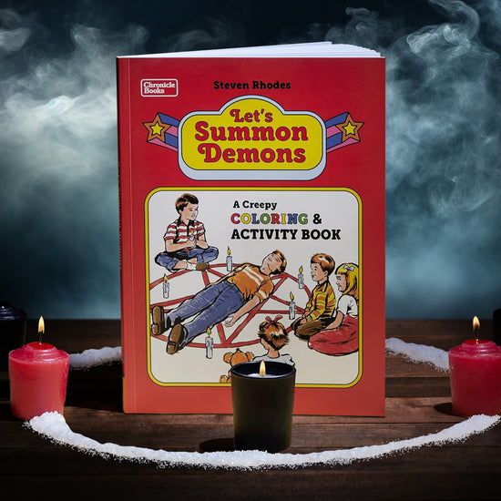 A copy of "Let's Summon Demons: A Creepy Coloring & Activity Book" standing in a salt circle amidst a misty background. The book has a primarily red cover with old-style cartoony characters illustrated on the front.