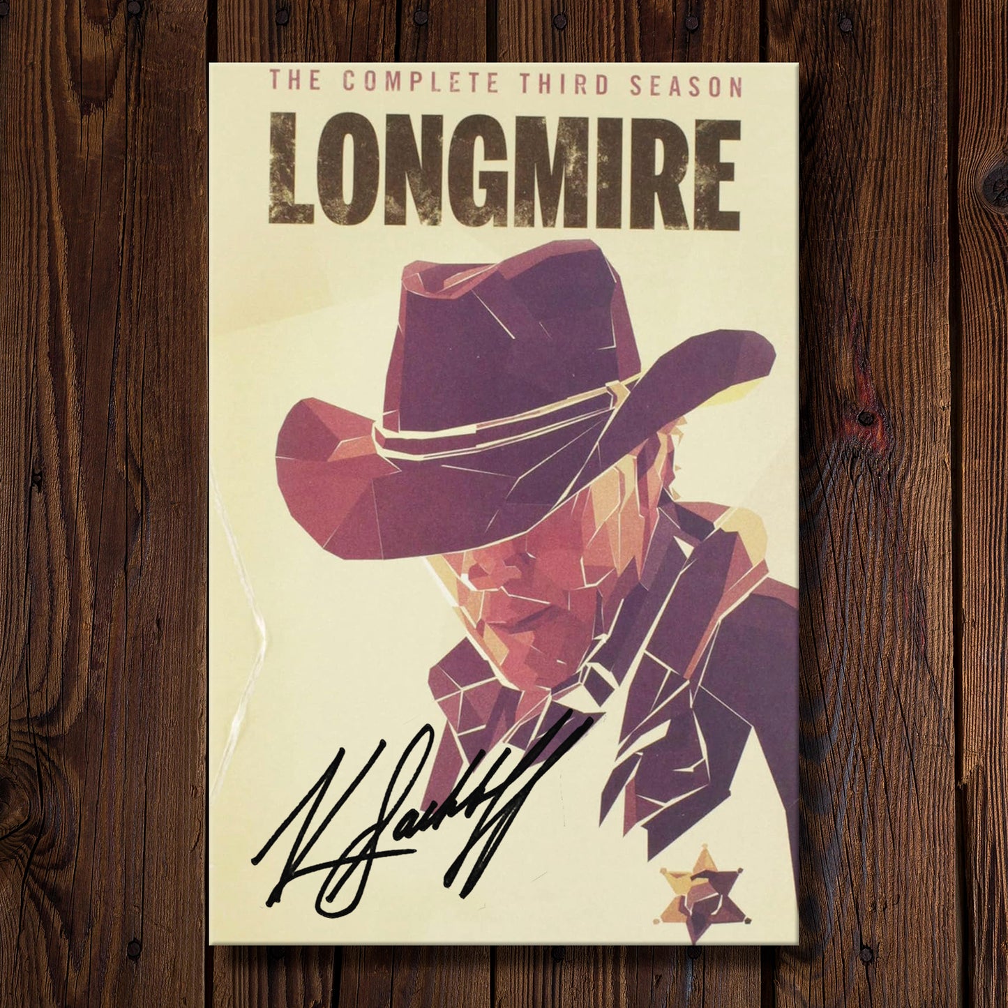 DVD cover of 'Longmire' season 3 on a wooden background. On the cover is Katee Sackhoff's autograph