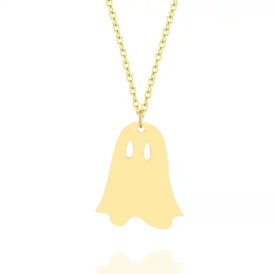A small gold pendant in the shape of a ghost, with two spots cut out at its eyes. The necklace hangs on a gold chain, against a white background.