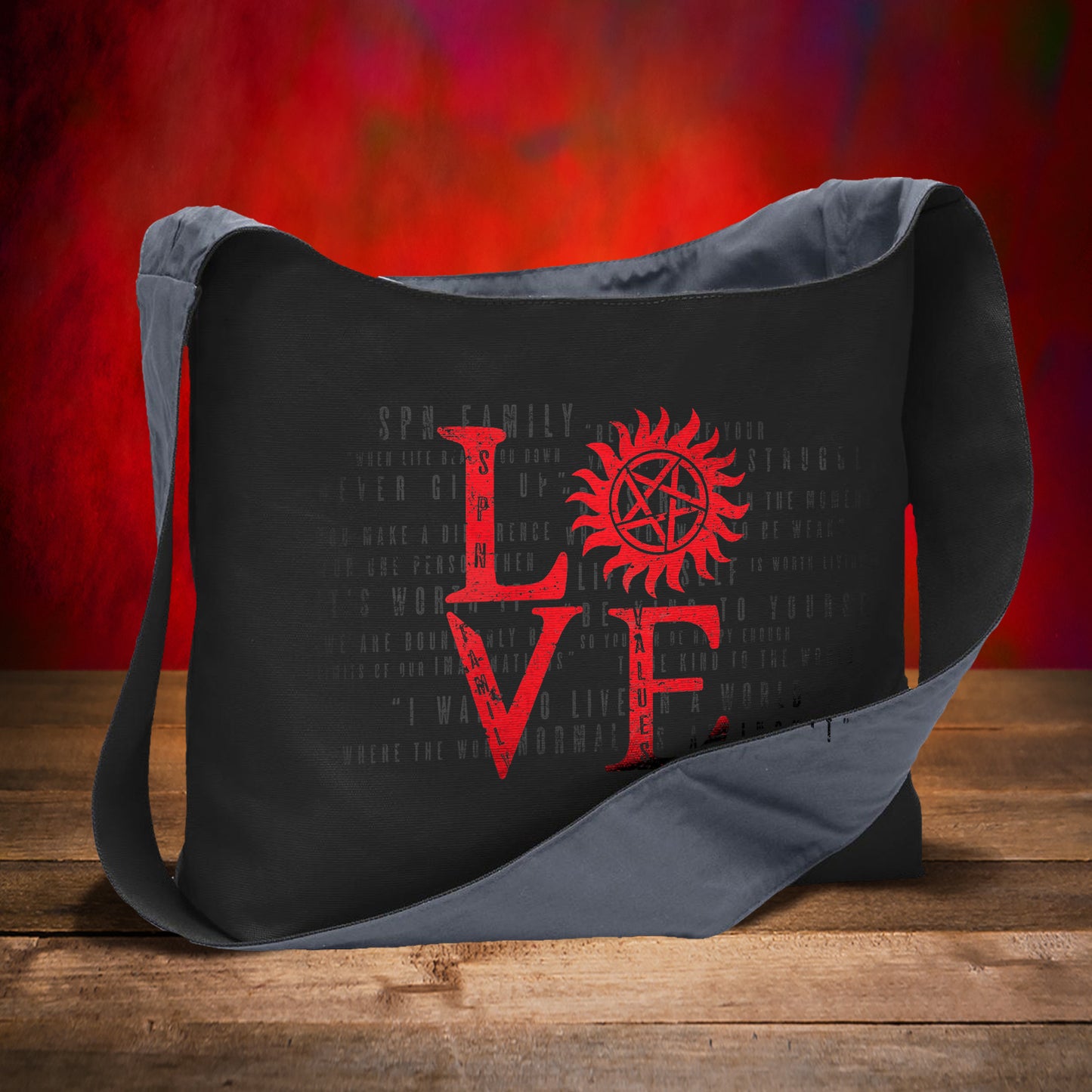 A black canvas sling bag on a wooden table, against a red background. On the front is red text saying "LOVE" in a square shape. The "O" in love is replaced by the anti-possession symbol.