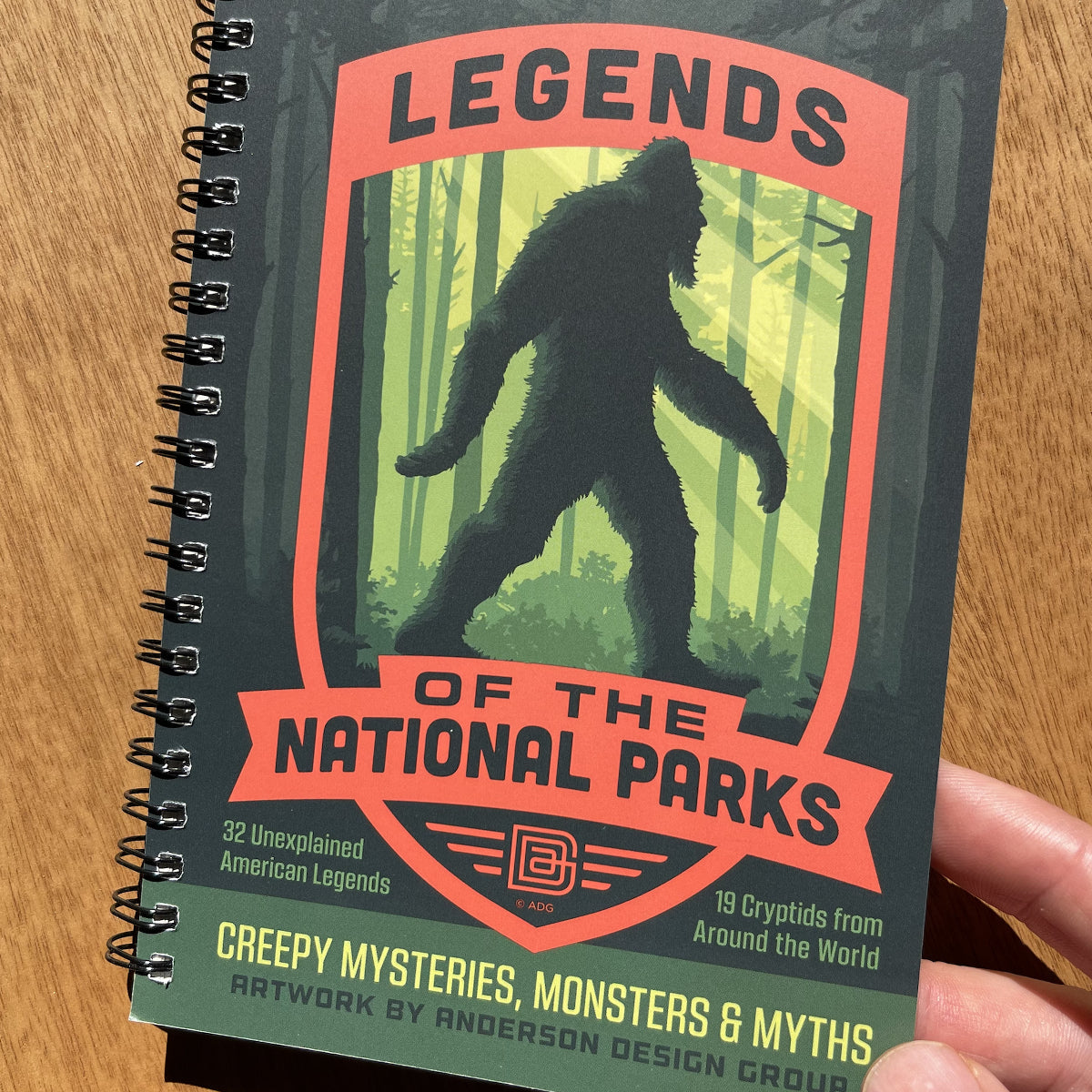 Notebook titled 'Legends of the National Parks' with a Bigfoot illustration on a wooden surface