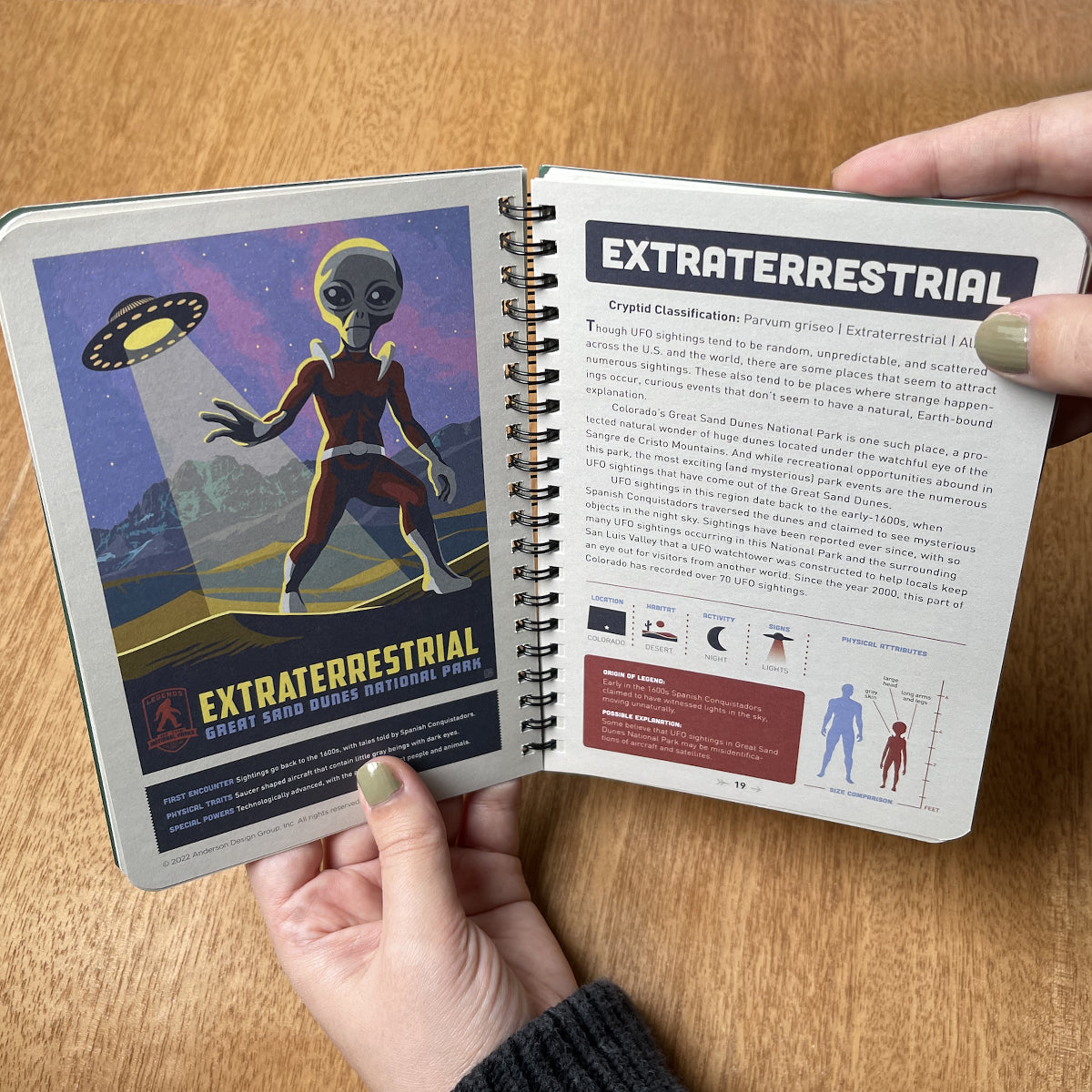 Open notebook with extraterrestrial-themed pages on a wooden surface