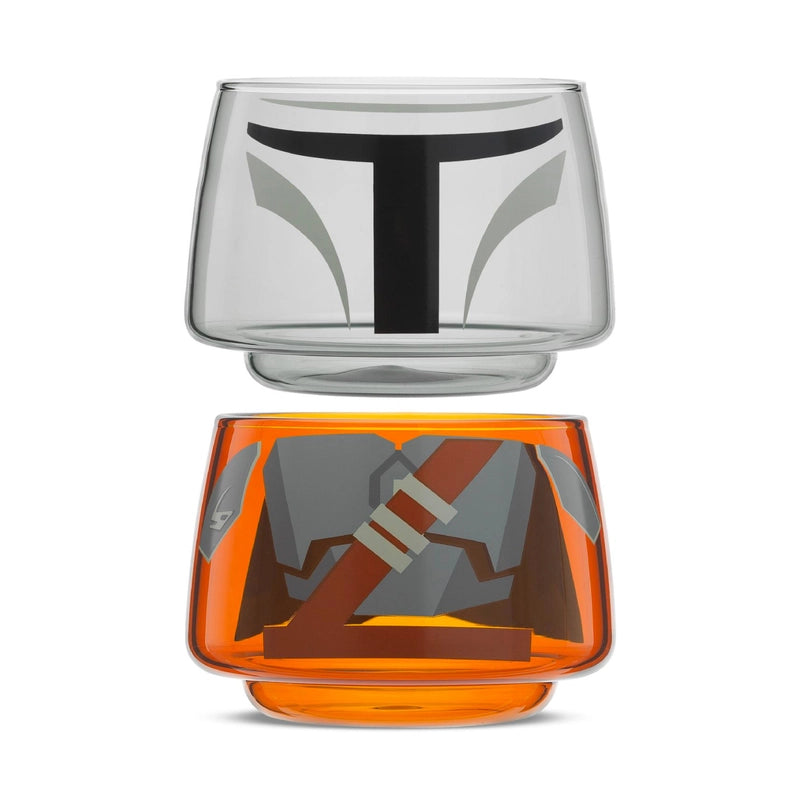 Two small drinking glasses stacked on each other against a white background. The two glasses combined depict the titular character from the Star Wars series The Mandalorian. The two glasses are slightly separated from each other.