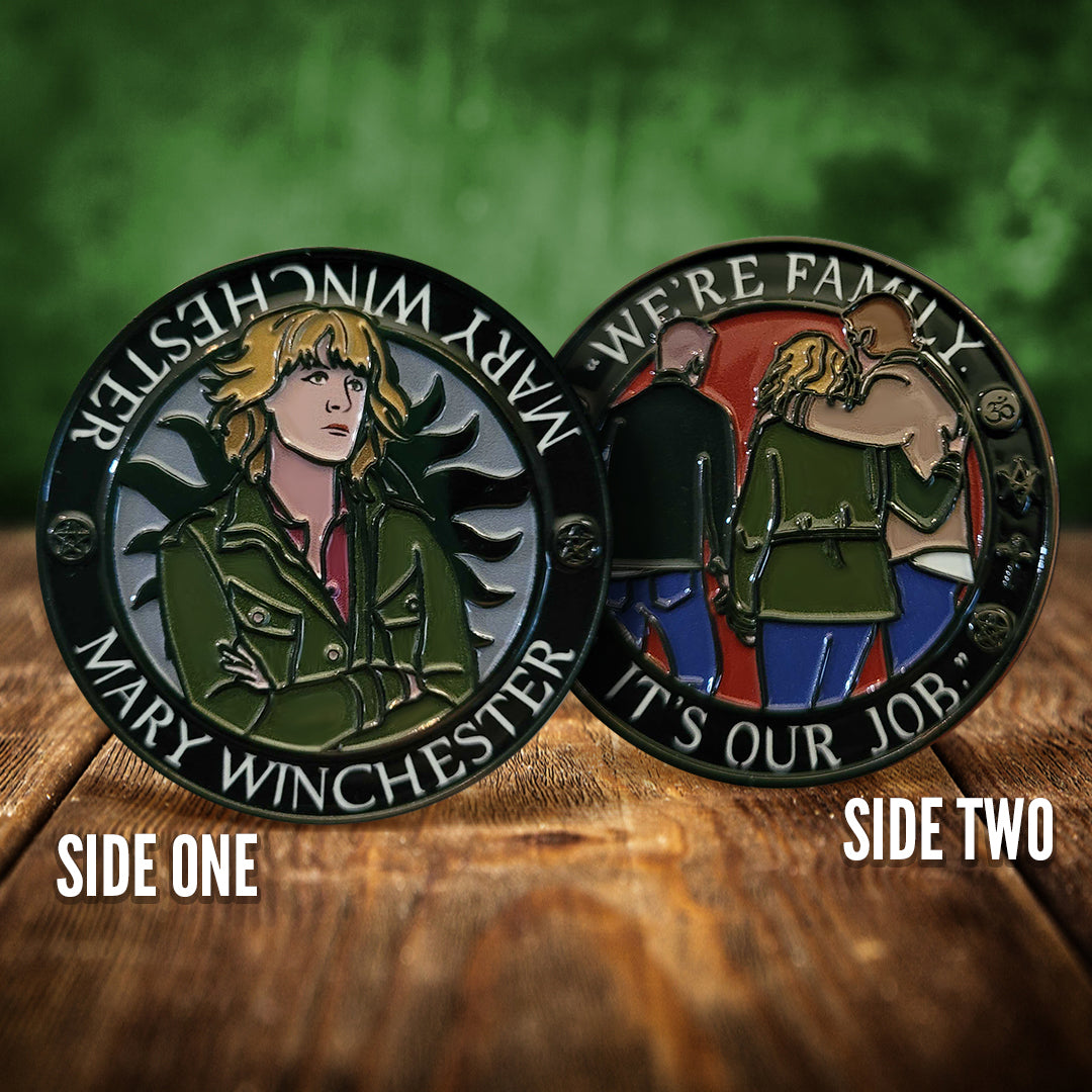 Front and back images of a challenge coin, side by side, on a wood table. The front depicts a drawing of Mary Winchester, wearing a green jacket. Behind her is the edge of the anti-possession symbol. The back of the coin depicts the backs of Mary, Dean, and Sam. White text around the edge says "We're family, it's our job"