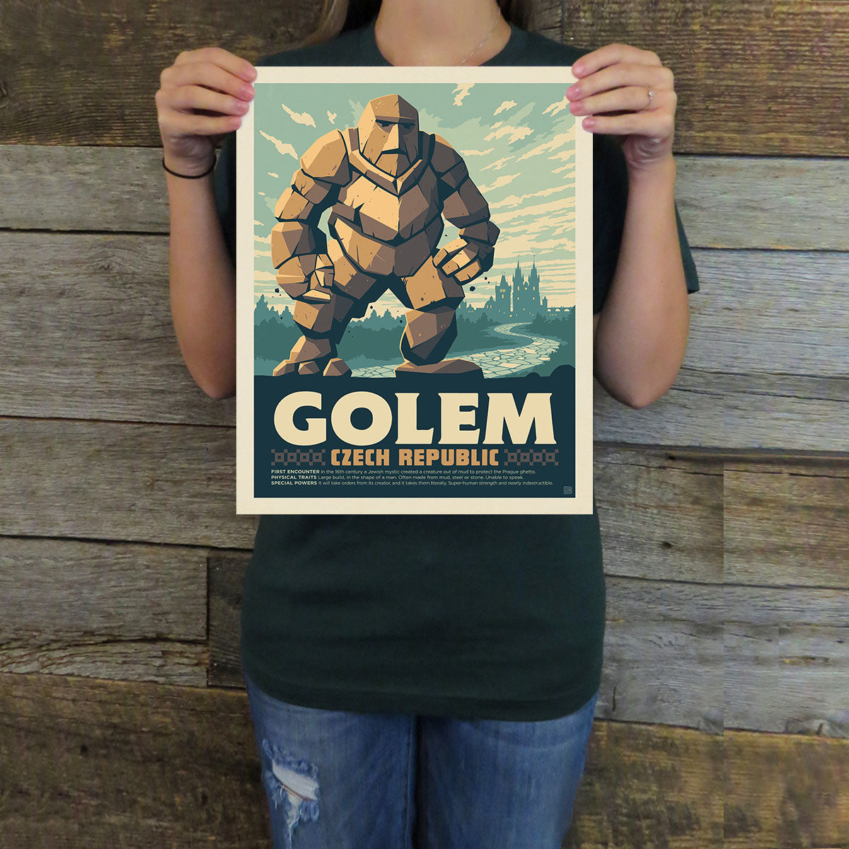 Person holding a poster of a golem with 'Golem Czech Republic' text against a wooden background