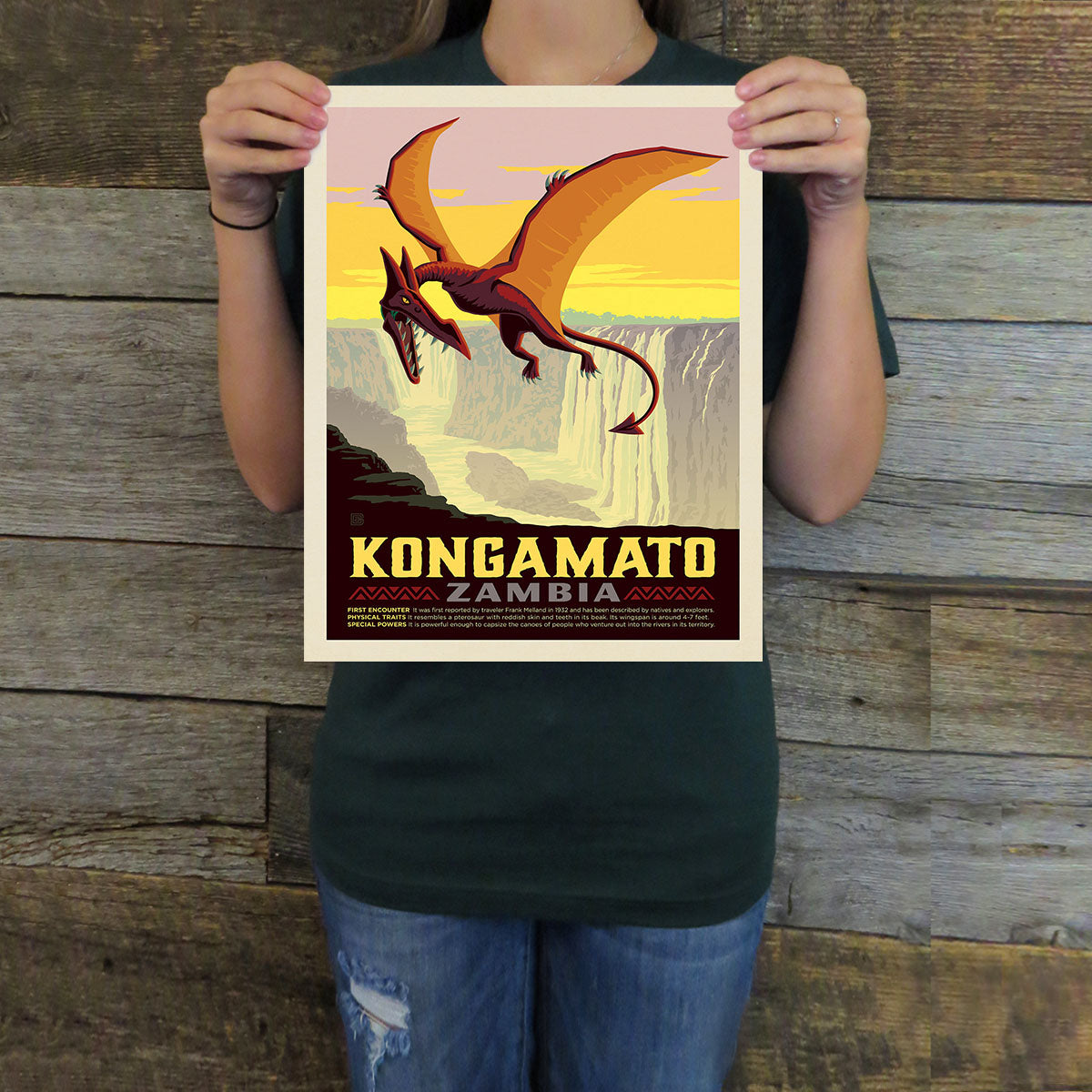 Person holding a poster with a dragon design and text against a wooden background