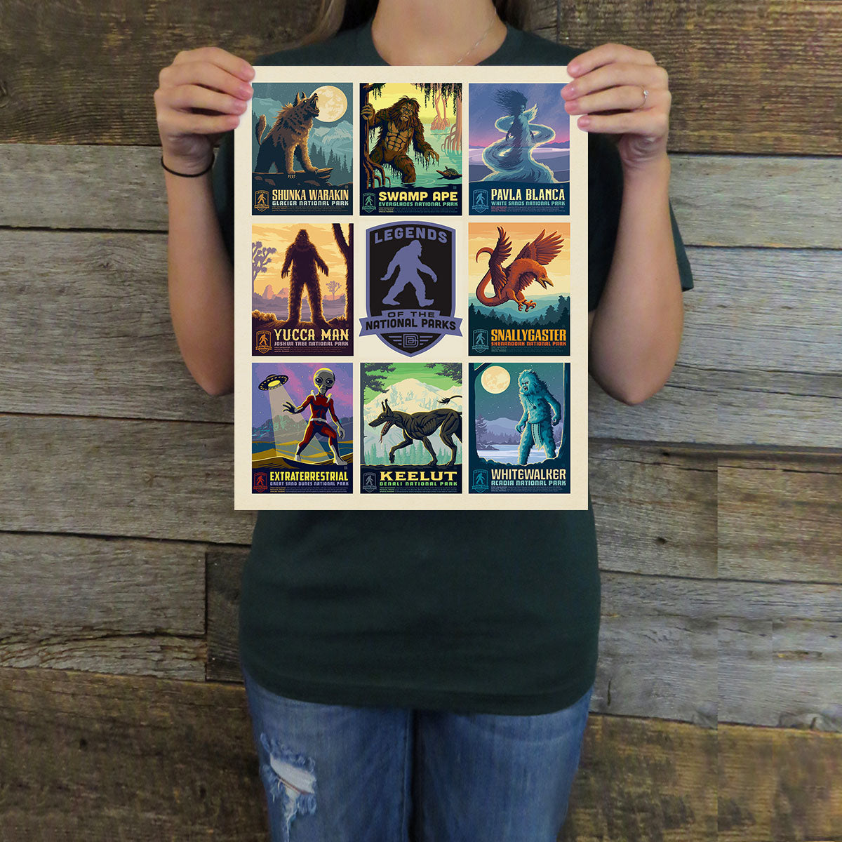 Person holding a poster with various illustrated characters against a wooden background