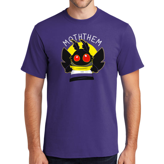 A male model wearing a purple T-shirt. A yellow circle in the center has a black moth head with red eyes, and black wings at the sides. The moth is holding a Non-binary Pride flag, in yellow, purple, white, and black. Above the image is white text saying "MOTHTHEM."
