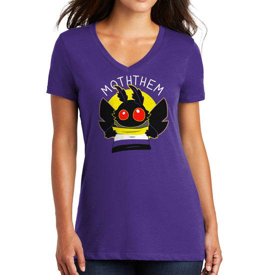 A female model wearing a purple T-shirt. A yellow circle in the center has a black moth head with red eyes, and black wings at the sides. The moth is holding a Non-binary Pride flag, in yellow, purple, white, and black. Above the image is white text saying "MOTHTHEM."