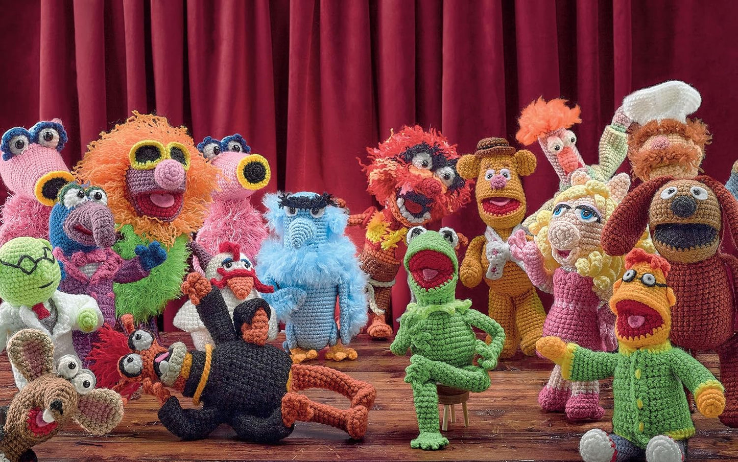 A collection of crochet Muppet characters on a stage.