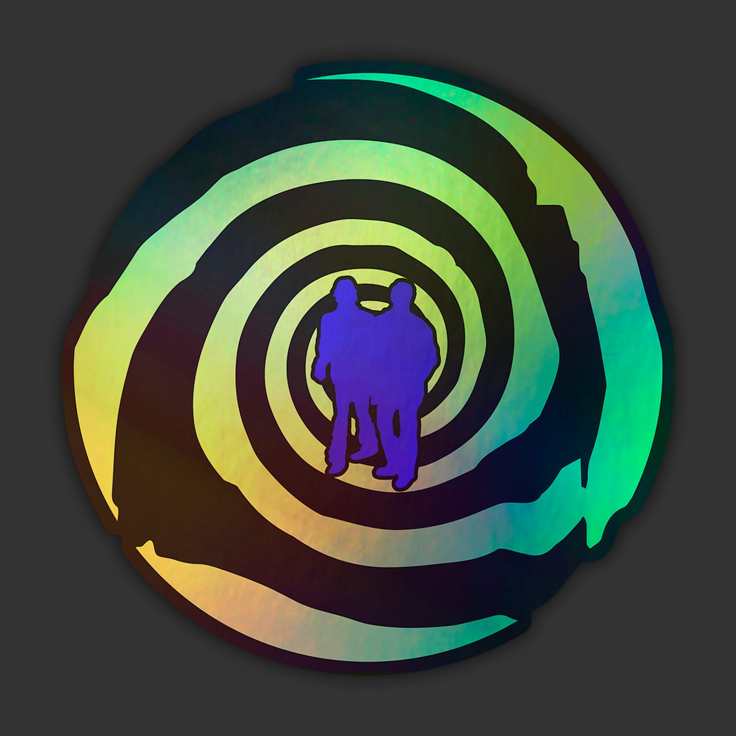 A holographic sticker depicting a green and black spiral. Two figures in blue silhouette are at the center.