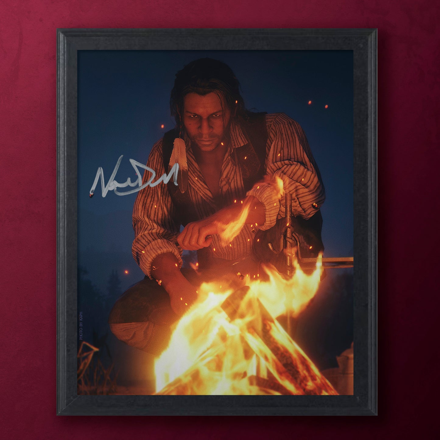 Framed artwork of a person by a campfire with a signature on a dark background