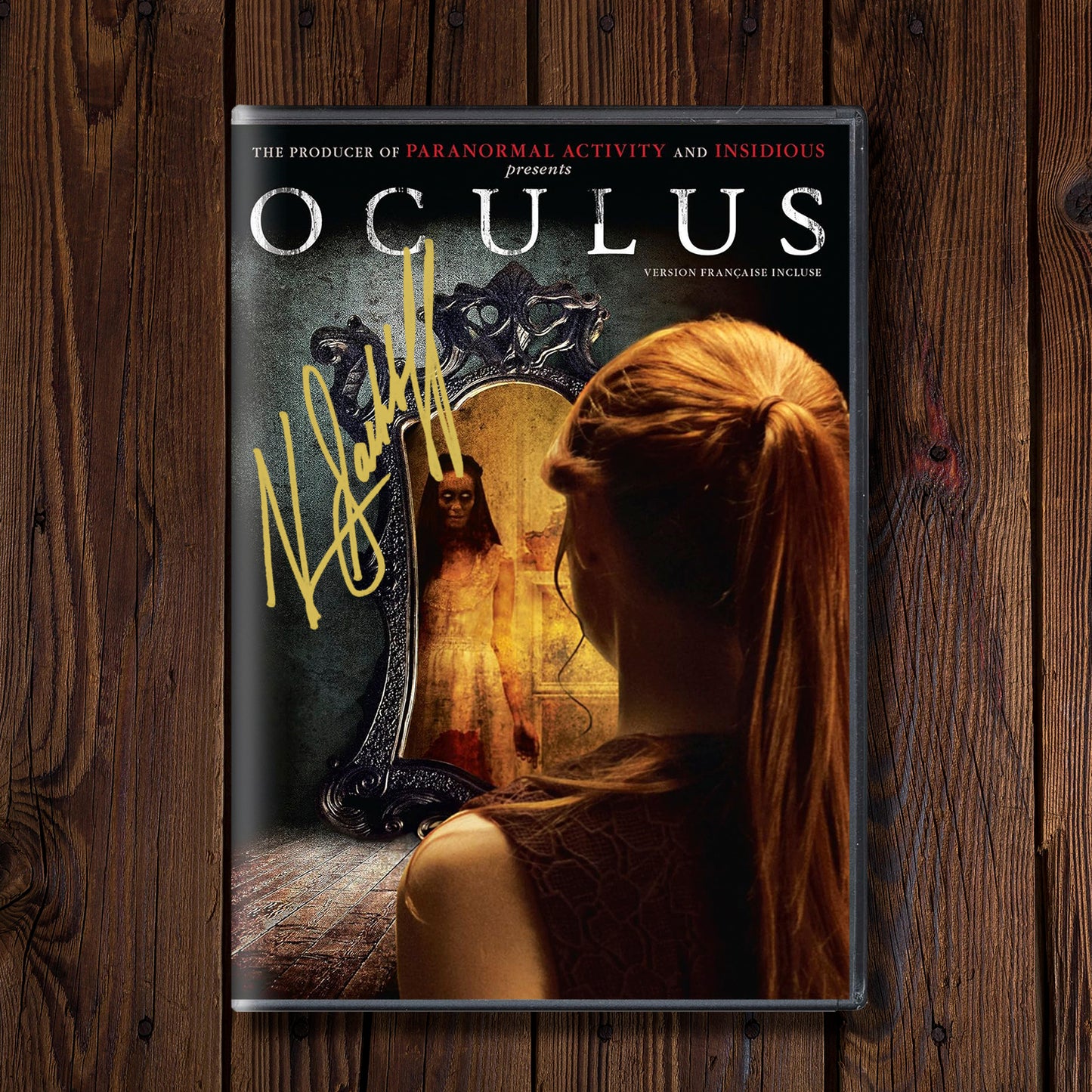 DVD cover of 'Oculus' on a wooden surface. On the cover is Katee Sackhoff's autograph