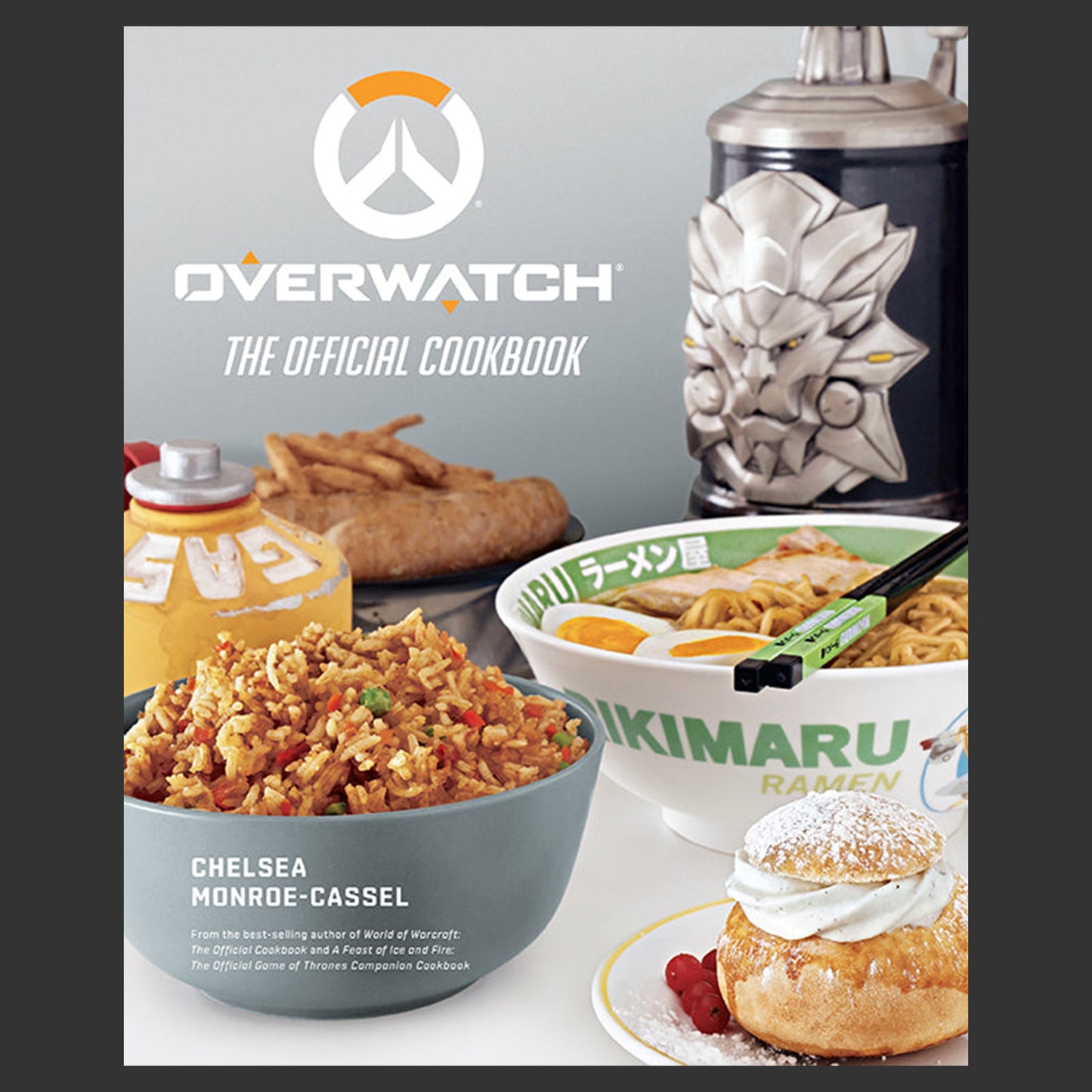 Cover of 'Overwatch: The Official Cookbook' with food items and Overwatch logo.