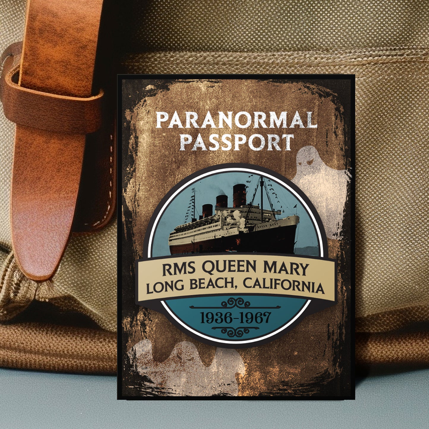 Close up on an enamel pin. The pin has a drawing of cruise ship in the center, surrounded by a stone-colored background. Two white ghost drawings are in the background. At the top is white text saying "Paranormal passport." Under the ship drawing is text saying "RMS Queen Mary. Long Beach, California 1936-1967."