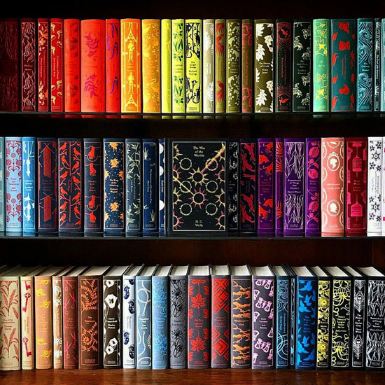 A bookshelf with three shelves on which a number of colorful, hardcover clothbound books sit in neat rows.