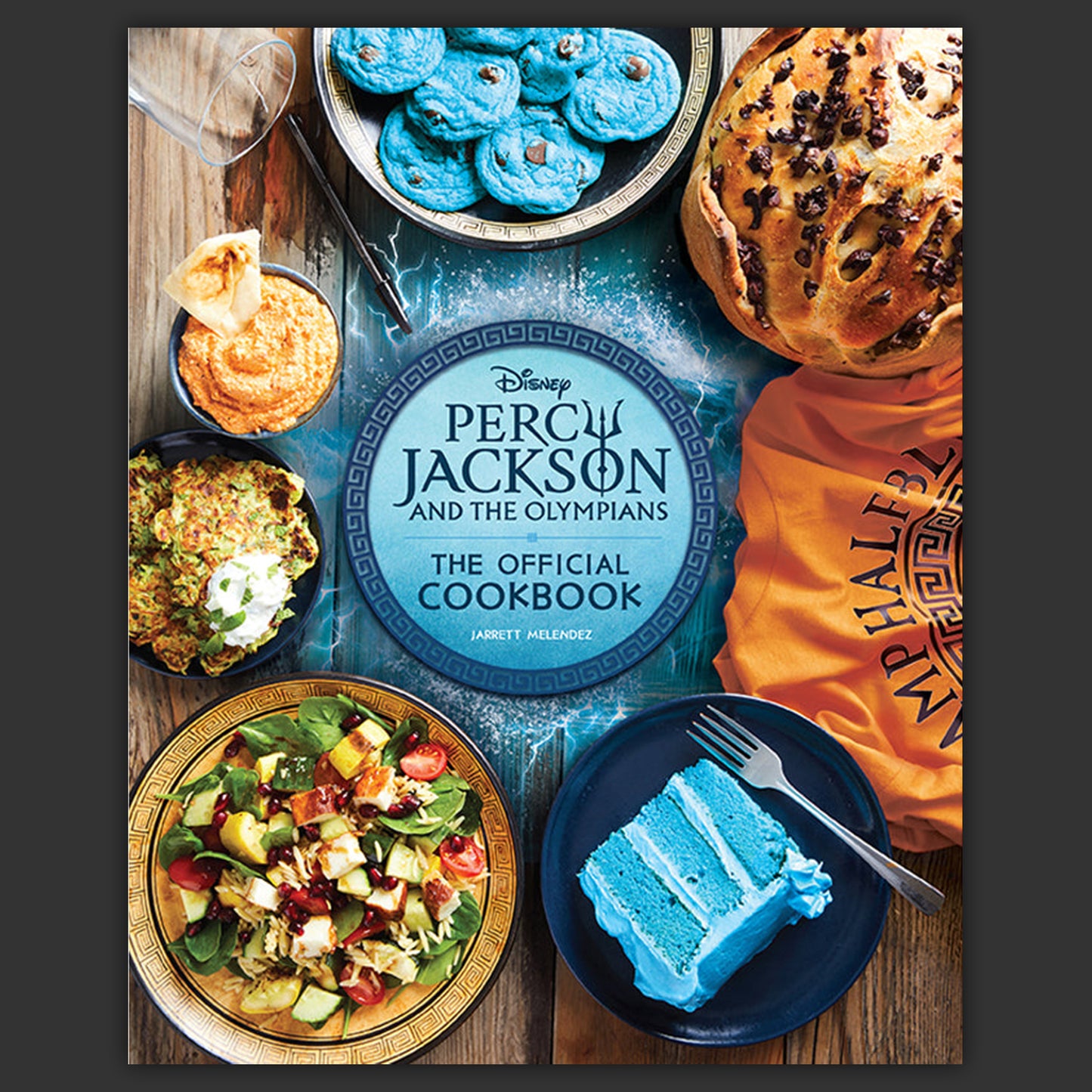 Disney Percy Jackson cookbook with food images on a wooden table