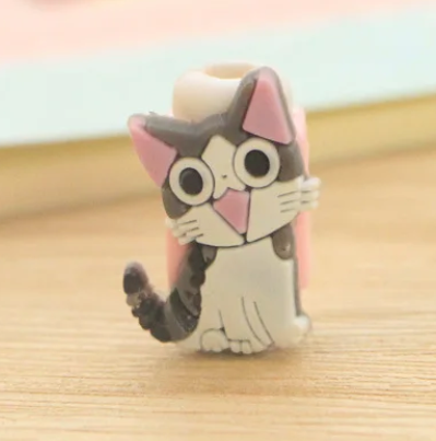 Close up view of a plastic phone charger clip, with a grey and white kitten on the front.