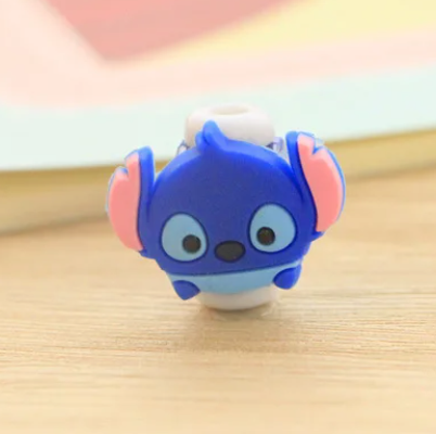 Close up view of a plastic phone charger clip, with Stitch from "Lilo and Stitch" on the front.