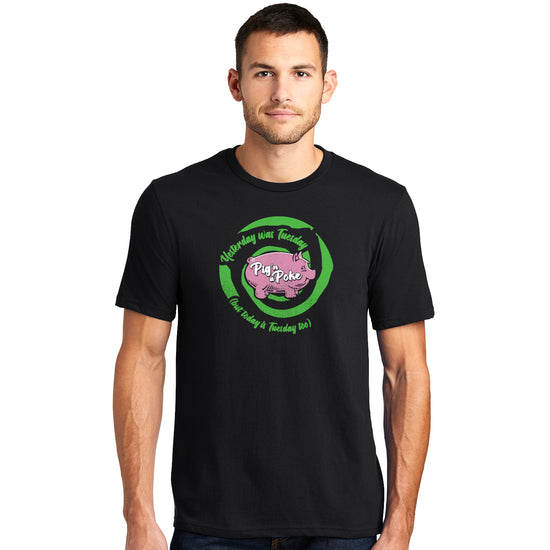 A male model wearing a black t-shirt. The front of the tee has a bright-green-and-black swirl and within the swirl reads "Yesterday was Tuesday (but today is Tuesday too)". There is a pink pink in the middle and white font that reads "Pig n' a Poke'.